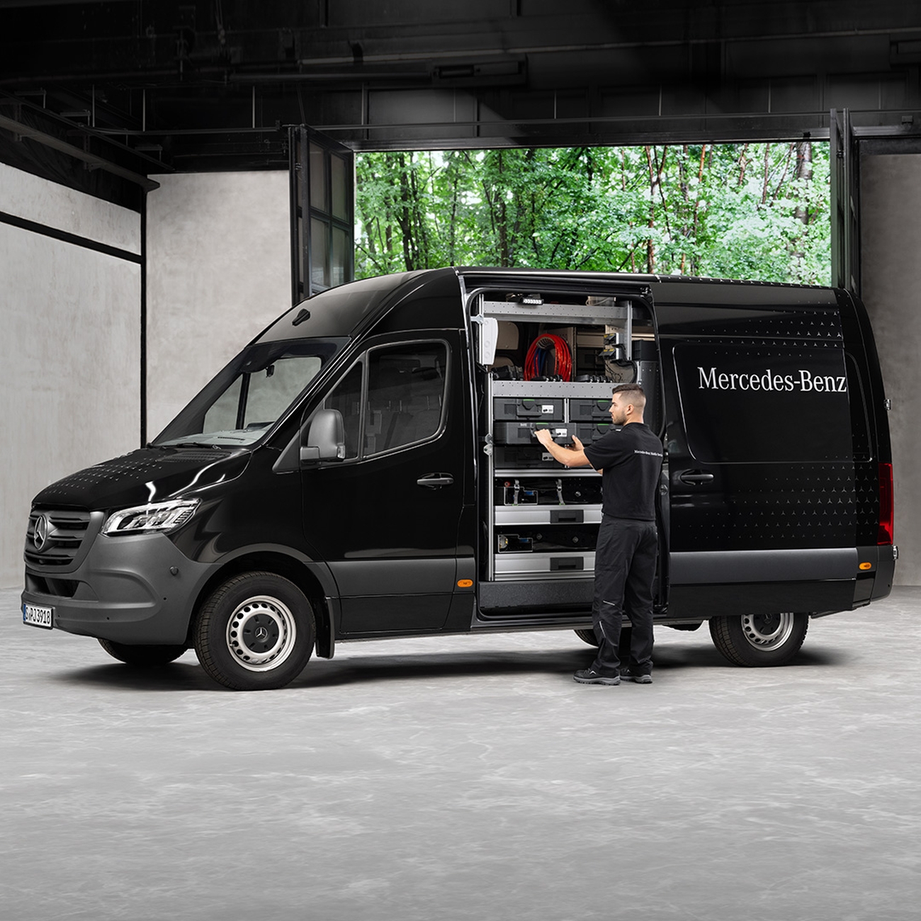 Techniker arbeitet an der technischen Ausstattung eines Servicefahrzeugs mit geöffneter Seitenklappe